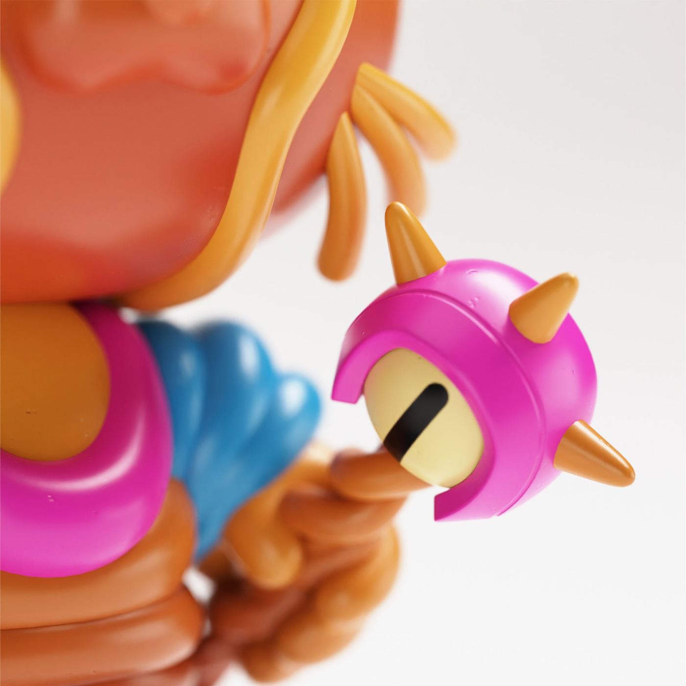 Close-up of a figure's pink spiked eye and orange tentacles