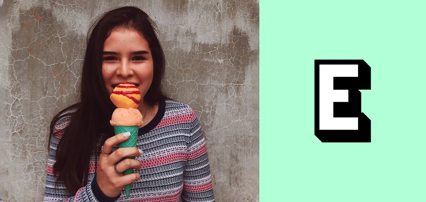 A woman eating an ice-cream cone beside a bold E on mint