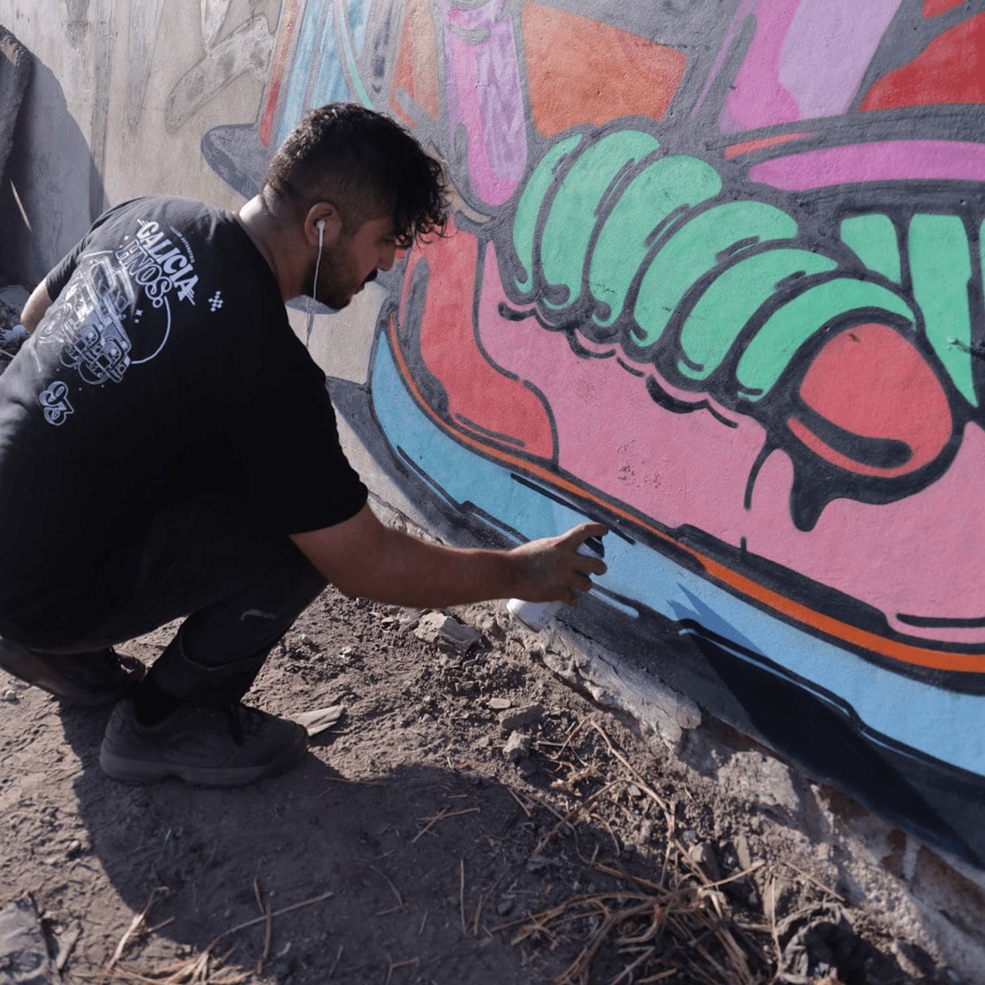 A graffiti artist crouched, spraying a mural