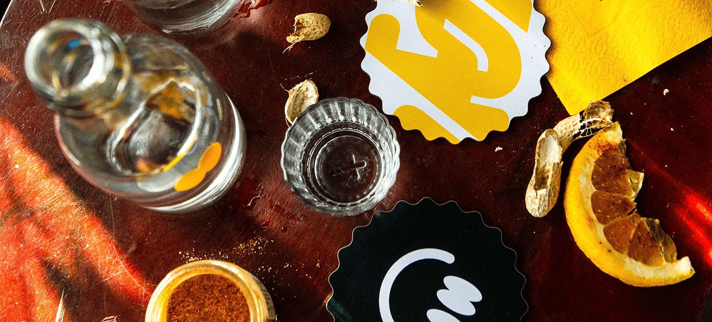 Mezcal bottle, glasses, orange slices and Sorbitos coasters from above