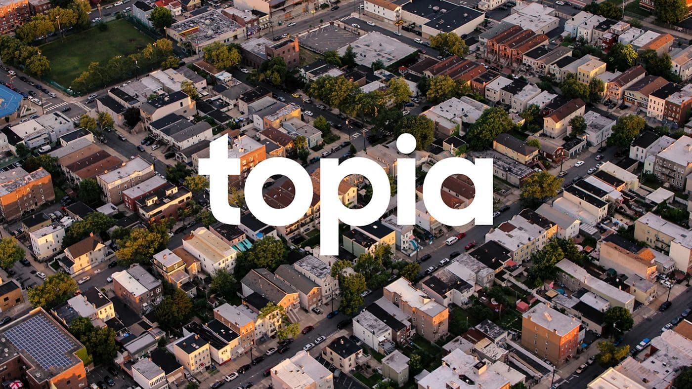 Topia wordmark over an aerial view of a neighbourhood